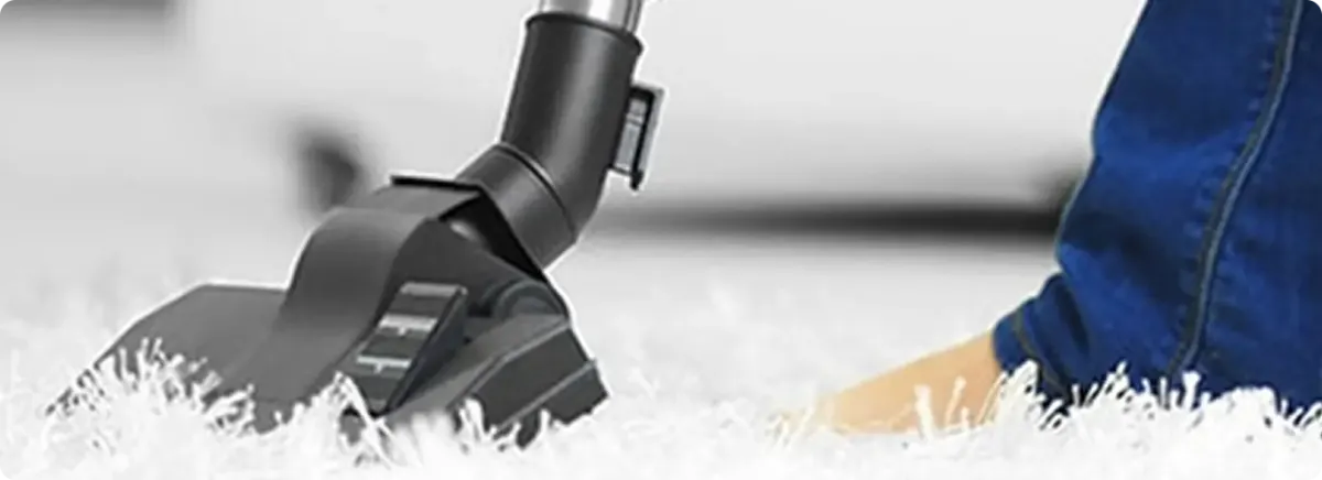 Close-up of a professional vacuuming a white carpet in Mount Hamilton.